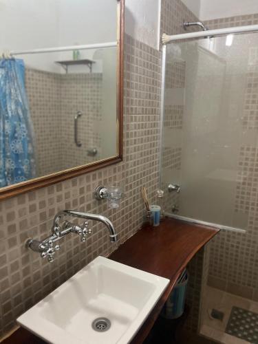 a bathroom with a sink and a mirror and a shower at Casa Chica in Cafayate