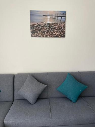 a gray couch with two blue pillows on a beach at Bayt Hassan S18 - Fabulous Roof top 1 bedroom apartment in Hurghada