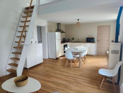 Il comprend une cuisine et un salon avec une table et un escalier. dans l'établissement Jolie maison brévinoise, à Saint-Brévin-les-Pins