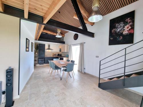 une salle à manger et une cuisine avec une table et des chaises dans l'établissement Appartement Duplex les Cerisiers - Bilhac, à Polignac