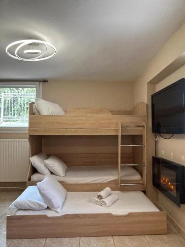 a room with two bunk beds and a flat screen tv at Your private villa in Ptolemaida
