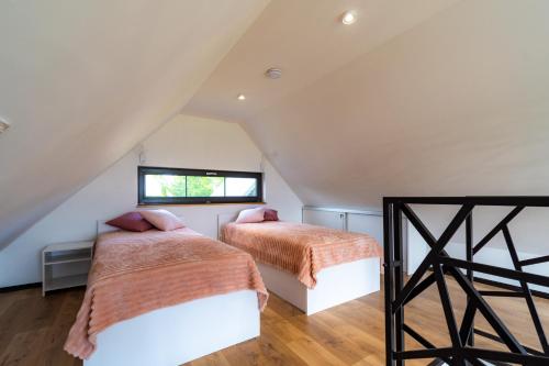 two beds in the attic bedroom of a house at Seaside Spokes in Wytowno
