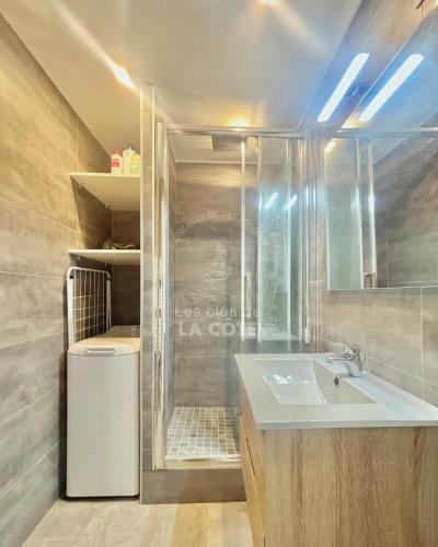 une salle de bain avec un lavabo et une douche dans l'établissement Le Bedford, à Le Touquet-Paris-Plage