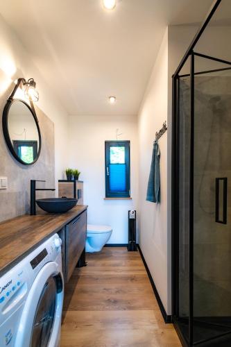 a bathroom with a washer and a sink and a washing machine at Seaside Spokes in Wytowno