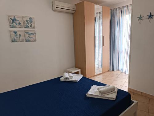 a room with a blue bed with towels on it at Appartamento G&G in San Vito lo Capo