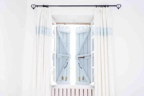- une fenêtre ouverte avec des rideaux blancs dans la chambre dans l'établissement La Bastoulie near Cordes-sur-Ciel, à Lacapelle-Ségalar