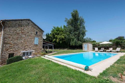 une piscine devant un bâtiment en pierre dans l'établissement La Bastoulie near Cordes-sur-Ciel, à Lacapelle-Ségalar