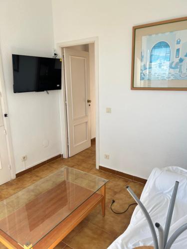 a living room with a glass coffee table and a tv at Atardeceres & Jacuzzi in La Manga del Mar Menor