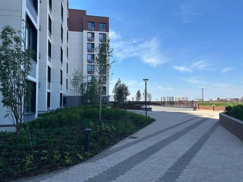 an empty street next to a tall building at Уютная квартира 5 минут от Барыс арены in Astana