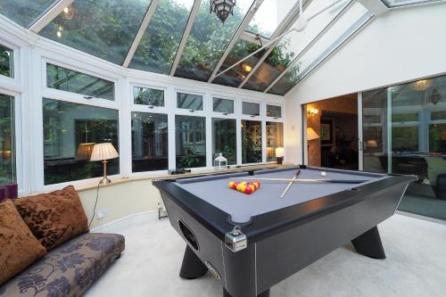 a pool table in a room with windows at Westmorland - 4 Bedroom House - FREE Parking for up to 7 Cars - Walking distance to QMC and University - Ideal for Contractors and Large Groups in Nottingham