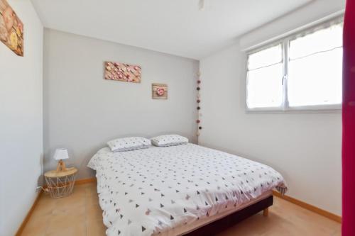 une chambre avec un lit et une fenêtre dans l'établissement Gîte tout confort 50 m2, 2 chambres, à Abeilhan