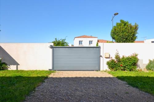 une porte de garage devant un bâtiment blanc dans l'établissement Gîte tout confort 50 m2, 2 chambres, à Abeilhan