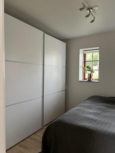 a bedroom with white cabinets and a bed at Stalden ved Hjarbækgård in Løgstrup
