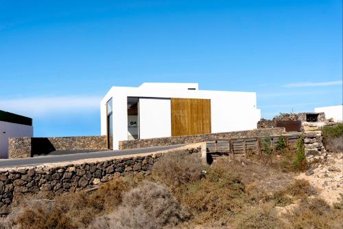 a house on a hill with a stone wall at Salty Villa by Aura Collection in El Roque