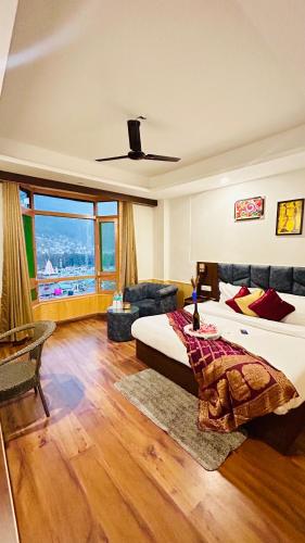 a bedroom with two beds and a large window at Hotel Meadows & Hotel Ocean Edge ! Family Hotel ! A couple Hotel ! Near to Hadimba Temple in Manāli