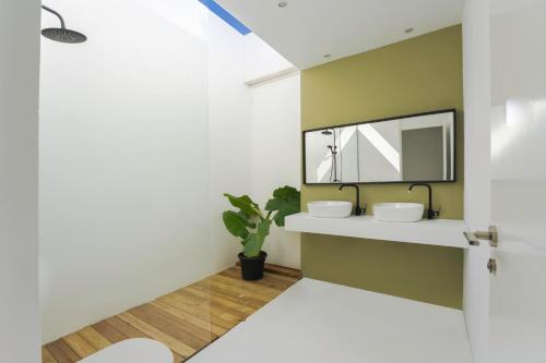 a bathroom with two sinks and a mirror at Salty Villa by Aura Collection in El Roque