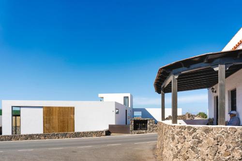 a man sitting at a bus stop next to a building at Salty Villa by Aura Collection in El Roque