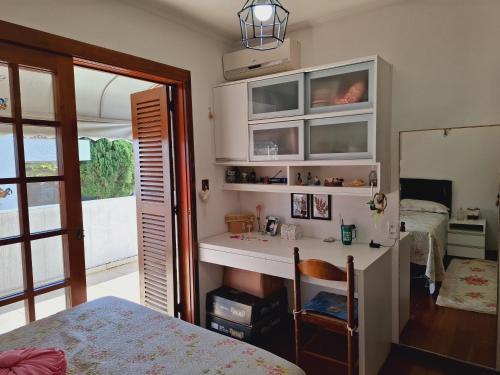 a bedroom with a desk and a bed and a mirror at Quarto familiar na cidade do Cristo in Encantado