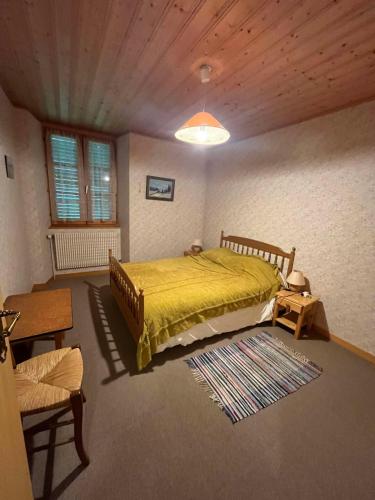 une chambre avec un lit avec un couvre-lit jaune dans l'établissement Maison confort à Rochejean, à Rochejean