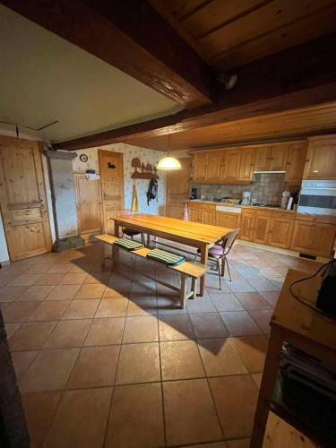 une cuisine avec une table en bois au milieu dans l'établissement Maison confort à Rochejean, à Rochejean