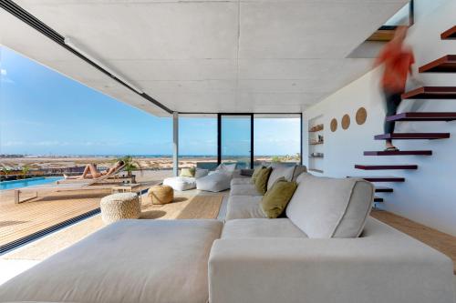 a living room with a white couch and stairs at Salty Villa by Aura Collection in El Roque