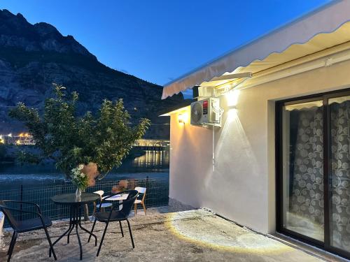a patio with a table and chairs and a view of the water at Breeze of the Drin Guesthouse Camping in Vau i Dejës