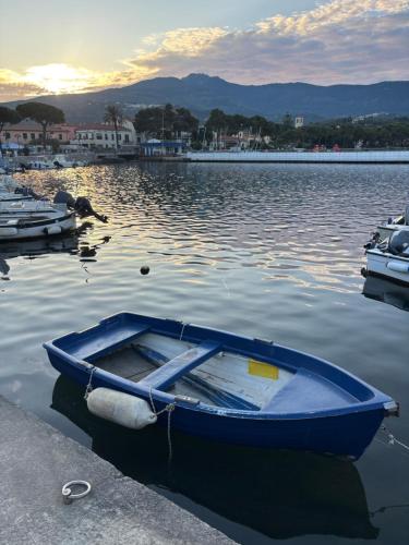 a blue boat is sitting in the water at La Palamita House in Marina di Campo