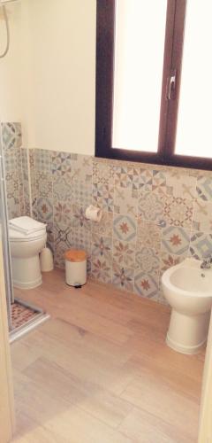a bathroom with a toilet and a sink at Karaly - Casa vacanze posto auto/moto in Cagliari