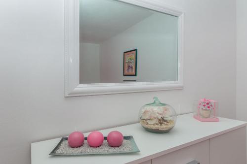 a bathroom with a mirror and pink eggs on a counter at Apartment Green view in Slime