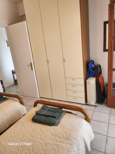 アギオス・イオアニス・ペリオンにあるAgios Ioannis apartmentのベッドとキャビネットとスーツケースのある寝室