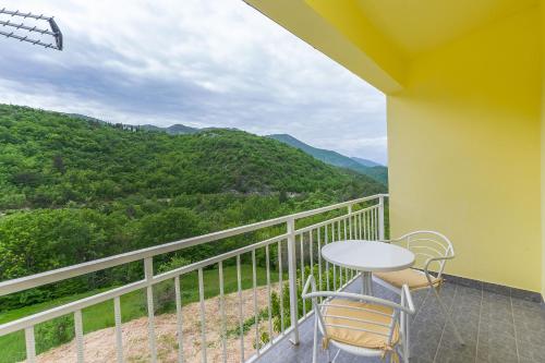 a balcony with a table and chairs and mountains at Apartment Green view in Slime