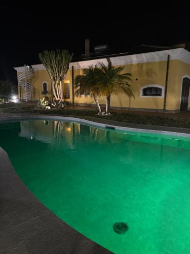 a swimming pool in front of a building at night at Villa Gabry in Capo dʼOrlando