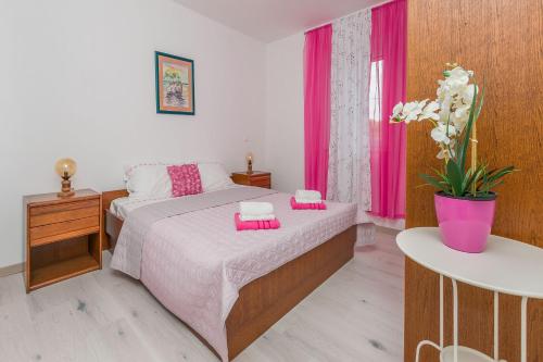 a bedroom with a bed with pink towels on it at Apartment Green view in Slime