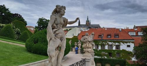 a statue of a woman on a bridge in a garden at At the Blue Lion & Parking Assistance in Prague