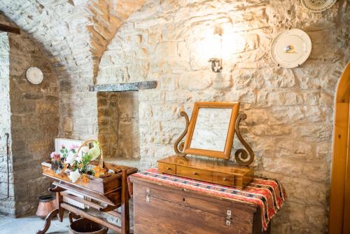 a mirror and a dresser in a room with a stone wall at Masseria Acquasalsa B&B TURISMO RURALE mini appartamenti SUPERIOR in Agnone
