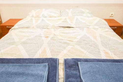 an unmade bed with two blue pillows on it at DOWNTOWN - BEST Price Small Apartment in Burgas City