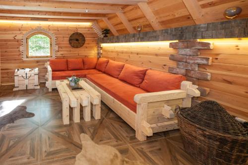 a living room with a couch in a log cabin at Wolf's Peak in Babljak
