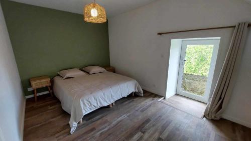 Un dormitorio con una cama y una ventana grande. en Maison DU VERGER, en Quarré-les-Tombes