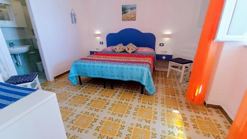 a bedroom with a bed with a blue headboard at Appartamenti Tina in Villa Restituta in Ischia