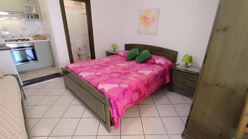a bedroom with a bed with a pink blanket at Appartamenti Tina in Villa Restituta in Ischia