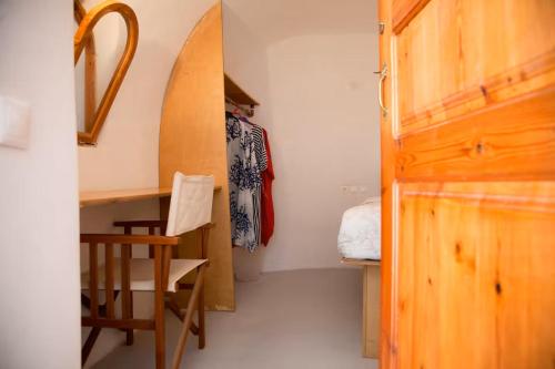 a room with a desk and a chair and a surfboard at Aegea Cave Houses in Mesaria