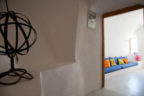a living room with a mirror and a blue couch at Aegea Cave Houses in Mesaria