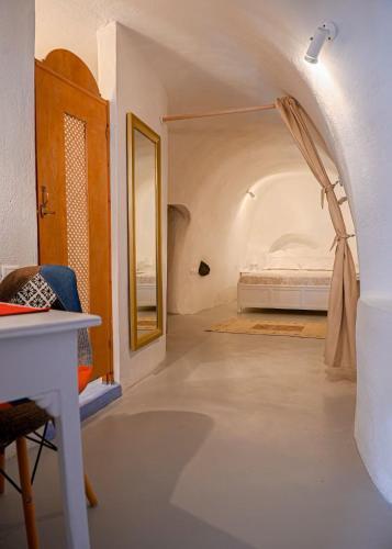 a bedroom with a bed in a room with a hallway at Aegea Cave Houses in Mesaria
