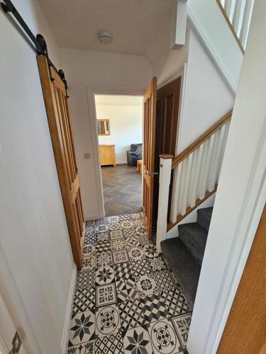 a hallway with a staircase with a tile floor at Modernised 3 Bed House in Wrexham