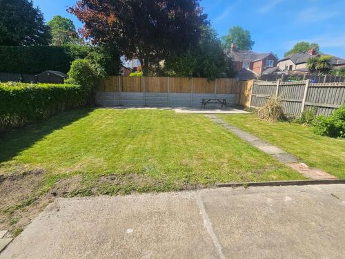 a yard with a fence and a bench in it at Modernised 3 Bed House in Wrexham