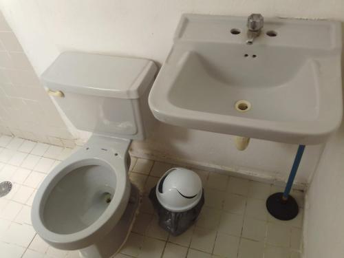 a bathroom with a white sink and a toilet at Apartamentos Cupules in Mérida