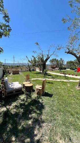 a group of chairs and tables in the grass at Tringa Guesthouse - Mrizi i Zanave in Fishtë