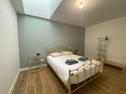 Cette chambre comprend un lit avec des draps blancs et du parquet. dans l'établissement Les gîtes du pécheur !, au Crotoy