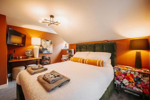 a bedroom with a large bed with orange walls at Unique Shrewsbury Rooms in Shrewsbury