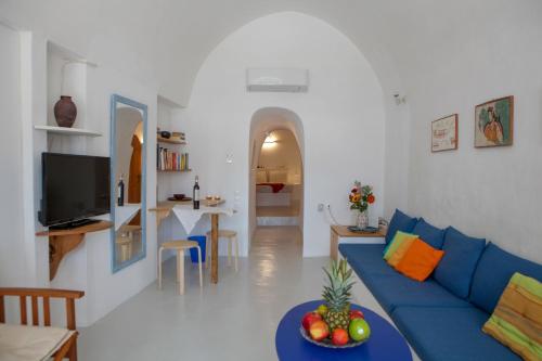 a living room with a blue couch and a table at Aegea Cave Houses in Mesaria